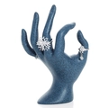 Silver snowflake and bell charm rings displayed on a dark blue hand-shaped stand - OK Hand / Blue