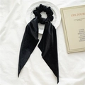 Detail of a black velvet scrunchie with ribbons on a white embossed decorative plate - Black Velvet Streamer