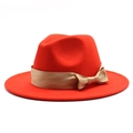 Detailed close-up of red wool felt fedora with elegant gold satin ribbon and bow accent - Orange Red