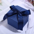 Premium blue square gift box featuring a matching blue ribbon bow on a soft fabric backdrop - Treasure Blue; String Lights (1 Meter Long)