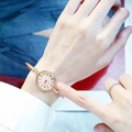Detailed shot of a gold bangle watch with a pink dial and twisted metal strap on wrist - Roman Numerals Rose Gold Band Pink Dial