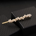 Eleganter goldener Perlenhaarschliff auf einer schwarzen strukturierten Schmuckschatulle - Haarnadel / Gold Perle Haarnadel