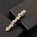Detailansicht einer goldenen Haarklammer mit funkelnden Strasssteinen auf schwarzer Box - Federclips / Gold Strass Haarclip