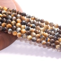 Round blue and brown tiger eye stone beads with cat eye effect on a wooden stand - Dreamy Tiger Eye