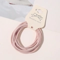 Detail of light pink elastic hair ties on a white card display with bow illustration - Girl Pink