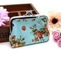 Detail of floral canvas wallet with vintage silver metal kiss-lock clasp on wood background - Blue