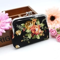 Detail shot of vintage floral canvas coin purse with metal clasp on wooden background - Black