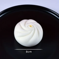 Realistic 8cm white steamed bun food model with yellow dot on a black display plate - 8cm Crab Roe Bun