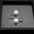 Elegant silver stainless steel hoop earrings with large white pearls on black tray - Clip-On Earrings / 14MM Pearl Pair / Silver/White