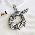 Elegante foulard in seta a pieghe con strisce diagonali nero e beige su un maglione bianco - Caffè Cornice Completa Geometrico
