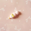 Close-up of pink resin food charm with a yellow bow for DIY phone case crafts - Pink Long Bread