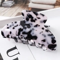 Detail of a large tortoiseshell acetate hair claw clip with smooth teeth on a tray - S139-7 Black & White Tortoiseshell