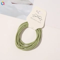 Detail of multi-pack high-elastic green hair bands on a white cardboard display card - Fruit Green