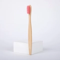 Eco-friendly bamboo toothbrush featuring soft pink nylon bristles and a natural wood handle - Pink
