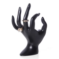 Porte-bijoux en forme de main noire présentant des bagues sur un fond blanc pur - Main OK / Noir