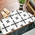 Semi-circular bath mat with black and white geometric diamond pattern on wood floor - Black & White Geometric