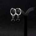 Primer plano de aros de acero inoxidable plateado con dijes de esferas negras brillantes - Aro de oreja perforado / 10MM Perla Par / Plata/Negro