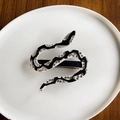 Schlangen-Haarclip mit schwarz-weißem Muster und Strasssteinen in weißer Schale - Schwarzer Federclip