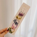 Set mit fünf handgefertigten Blumen-Haargummis in verschiedenen Farben auf Displaykarte - Holz-Stil Blume