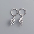 Dettaglio macro di orecchini a cerchio con serpente in argento S925 su sfondo grigio - Argento 925 / Oro Bianco