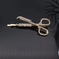 Macro detail of gold scissors hair clip encrusted with sparkling clear rhinestones - Gold Scissor Shape