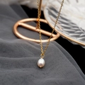 Elegant gold chain necklace with a white teardrop freshwater pearl pendant on grey mesh - Necklace