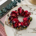 Red plaid flannel scrunchie with snowflake patterns on a decorative marble plate - Red Tartan Snowflake