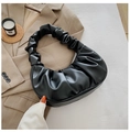 Primer plano de bolso fruncido negro con asa estilo scrunchie sobre una chaqueta elegante - Negro