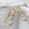 Detailed view of long gold tassel earrings with multilayer snake chains on white silk - Gold Plated Copper / Gold
