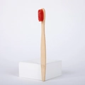 Eco-friendly bamboo toothbrush with soft red nylon bristles on a white background - Red