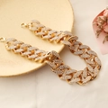 Exaggerated gold Cuban link necklace with full rhinestones on beige ceramic plate - Necklace / Gold