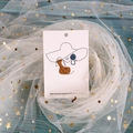 Abstract metal wire face earrings with blue and brown geometric charms on display card - 6x9cm