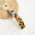 Close-up of tortoise shell pattern acetate hair clip on a natural woven background - Acetate Light Tortoise Shell