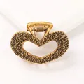 Close-up of golden heart claw clip with granular texture and hollowed center design - Heart - Antique Gold