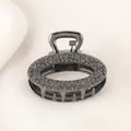 Macro detail of dark grey metal hair claw clip with rose floral embossed texture - Oval - Gun Black