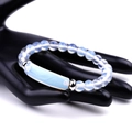 Detail showing translucent light blue beaded bracelet with silver spacers on hand model - Opal