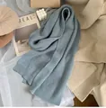 Detail eines graublauen Strickschals mit weicher Rippstruktur in gemütlichem Ambiente - Elefantenblau