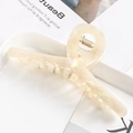 Close-up of a large cream acetate hair claw with a strong metal spring on a tray - S137-2 Pearly Beige
