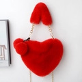 Detail of red heart-shaped faux fur handbag with gold chain strap and plush ball charm - Red