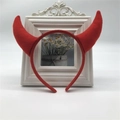 Detail showing the red plush devil horns headband placed in front of a white photo frame - Red Horn Red Headband