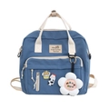Detailed shot of blue canvas bag featuring a cute sunflower plush charm and badges - Blue