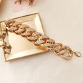 Detail of a gold-plated chunky necklace with rhinestones on a decorative tray - Bracelet / Gold