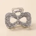 Macro shot of vintage matte silver alloy hair claw with bow shape and textured metallic surface - Bowknot - Antique Silver