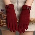 Detailed view of burgundy velvet gloves featuring a leather bow and warm winter texture - Red
