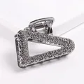 Detailed macro view of geometric hollow triangle hair claw with silver hammered texture - Triangle - Gun Black