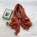 Brick red cashmere feel scarf with fringe tassels on white bedding with a book - Concubine Red