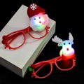 Detail of LED glowing Santa and Reindeer glasses with red frames on a black background - Glowing Christmas Glasses