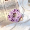 Elegant purple velvet scrunchie for bun hairstyles placed on a stylish newspaper background - Taro Purple