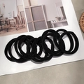 Set of durable black high-elastic hair ties displayed on a magazine in an art studio - 10 Pcs/Set / Black