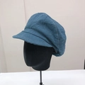 Detail of navy blue newsboy cap featuring white contrast stitching and panel construction - Blue